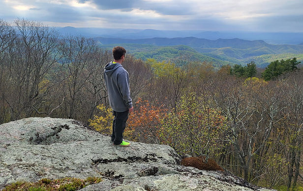 A father and son walk together through a wooded trail